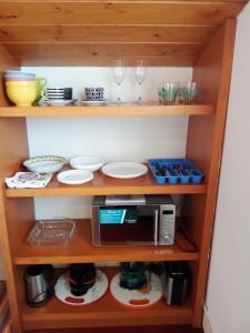 un estante con microondas, platos y vasos en Mundaka Vista Mar L-BI-52, en Mundaka