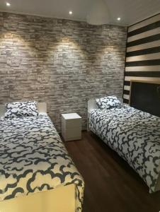 a bedroom with two beds and a brick wall at Warm and cozy house in Rovaniemi