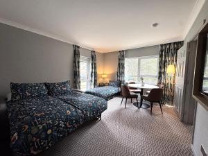 Un dormitorio con una cama y una mesa dentro. en Hilton Cobham, en Cobham