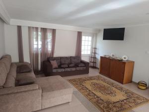 a living room with a couch and a tv at Casa do Outeirinho in Campos