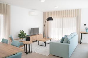 een woonkamer met een bank, stoelen en een tafel bij Casa Encanto da Foz - BY SCH in Foz do Arelho