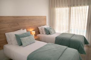 een slaapkamer met twee bedden en een raam bij Casa Encanto da Foz - BY SCH in Foz do Arelho +24 foto's