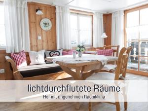 a living room with a table and a couch at Landhaus Waibelhof in Gunzesried +45 photos