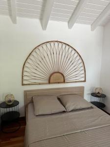 a bedroom with a bed with a large headboard at Studio accueillant au Gosier avec belle terrasse in Le Gosier