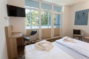a hotel room with two beds and a window at Hotel Seebrücke in Lubmin