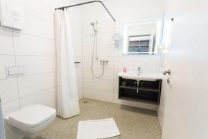 a bathroom with a toilet and a sink and a shower at Hotel Seebrücke in Lubmin +38 photos