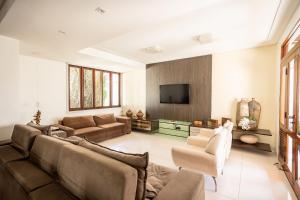 a living room with a couch and a tv at Casa Jardim - Praia do Bessa por Carpediem in João Pessoa