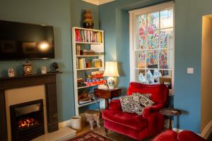 a living room with a red chair and a fireplace at 5 Raglan Street in Beaumaris