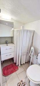 a bathroom with a white shower curtain and a sink at Chalet in Plouër-sur-Rance