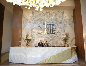 deux femmes debout à un bureau de réception dans un hall dans l'établissement Hotel Duble, à Navojoa 25 autres photos