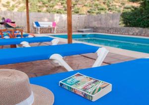 un libro sentado en una mesa junto a una piscina en Villa 291 by Villamya, en El Gastor