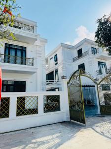 a white building with a gate in front of it at Villa 4PN Dream in Dong Hoi