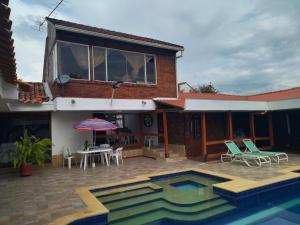 a house with a swimming pool in front of a house at Villa Juan jose in Anapoima