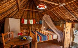 a room with a bed and a table in a hut at Casas Karen in Los Caños de Meca