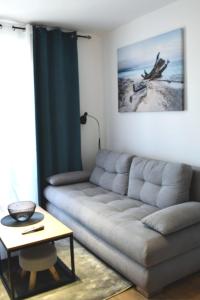 een woonkamer met een bank en een tafel bij Apartman Anna Srebrno jezero in Veliko Gradište