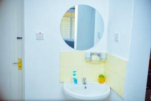 un baño con lavabo y espejo en Modern, Spacious , Executive 1Bedroom Apartment, Milimani, Kisumu, Kenya, en Kisumu