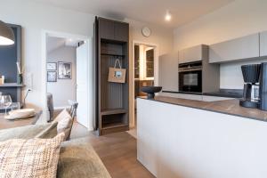 a kitchen and living room with a counter top and a table at Alte Schule Westerhever Dünenkieker in Westerhever