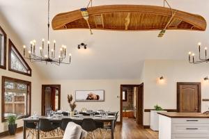 ein Esszimmer mit einem Tisch und einem Kronleuchter in der Unterkunft Front RIVER private BEACH 2 HOT TUBS 15 p SAUNA in Labelle