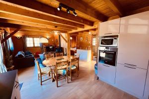 a kitchen and dining room with a table and a refrigerator at BEAUTIFUL CHALET in nature near Gerardmer! in Rochesson