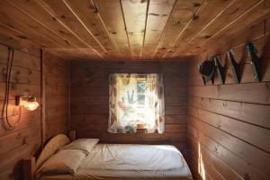 a small room with a bed and a window at Moose Point Cabin in Greenville +1 photo