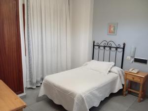 a small bedroom with a bed and a table at HOSTAl LUJUAN in Guadalupe +8 photos