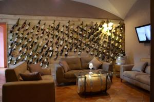 a room with couches and a wall of wine bottles at Mingone Hotel Ristorante in Isola del Liri