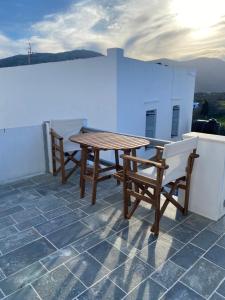 a wooden table and two chairs on a roof at Artemonas White Escape in Sifnos