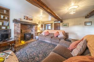 un soggiorno con due divani e un camino di Drawell Cottage - Situated on a working farm a Sedbergh