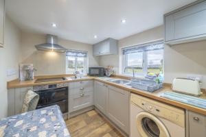 una cucina con lavandino e lavastoviglie di Drawell Cottage - Situated on a working farm a Sedbergh
