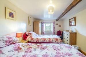 una camera da letto con due letti e un comò di Drawell Cottage - Situated on a working farm a Sedbergh