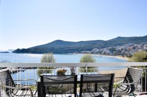 Un balcón con mesa y sillas y una playa. en Beach Side Apart III, en Kavala