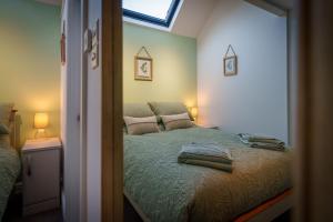 a bedroom with a bed with two pillows and a window at Bell Cottage - Cockermouth is five minutes walk to pubs, restaurants and shops in Cockermouth