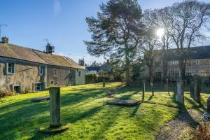 a field with a group of houses and a tree at Bell Cottage - Cockermouth is five minutes walk to pubs, restaurants and shops in Cockermouth