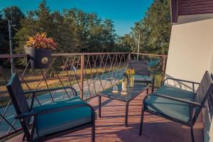three chairs and a table on a patio at Kuća za odmor Grđan in Slatinski Drenovac
