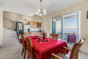 une salle à manger avec une table avec une nappe rouge dans l'établissement Spacious & Charming Apartment 128 m2 with Sea View, à Supetar