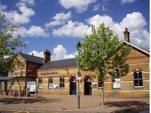 ein großes Backsteingebäude mit einem Baum davor in der Unterkunft Modern Penge East Apartment in Sydenham