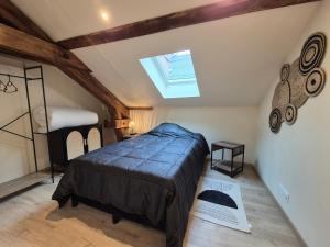 ブール・サン・モーリスにあるT4 BOURGEAT - Superbe appartement 5 pers - Centre villeのベッドと天窓のある屋根裏部屋の寝室