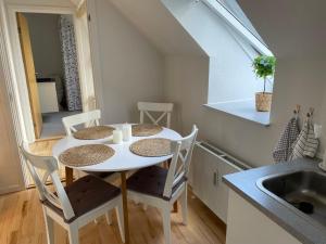 a kitchen with a table and chairs and a sink at Herning City Apartments in Herning