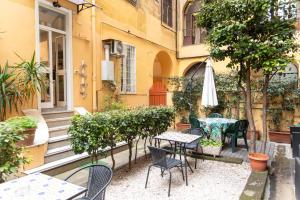 a patio with tables and chairs in front of a building at Parri Silton in Rome