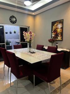 a dining room with a white table and red chairs at CASA ALTO PADRÃO - CoP30 in Belém