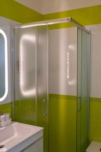 a bathroom with a shower with green walls and a sink at Albachiara in Bari +5 photos