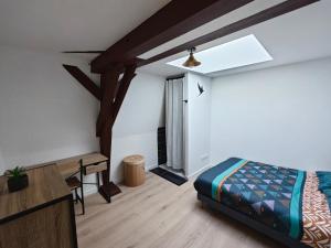 ein Schlafzimmer mit einem Bett und einem Schreibtisch darin in der Unterkunft Les Magnolias in Brou-sur-Chantereine