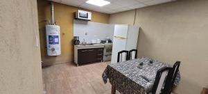 a room with a table and a kitchen with a refrigerator at Gasb in Choele Choel