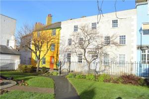 a large white building with a fence in front of it at Monmouth House Apartments, Lyme Regis Old Town, dog friendly in Lyme Regis