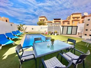 un patio con tavolo e sedie e una piscina di El Mar House & Private Heated Pool ad Adeje