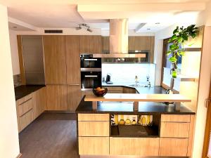 a kitchen with wooden cabinets and black counter tops at Appartement Mölltalblick in Napplach