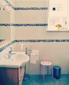 a white bathroom with a sink and a stool at B&B Casa Dolce Casa Monopoli in Monopoli +56 photos
