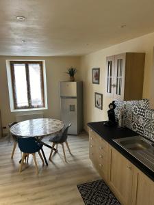 a kitchen with a table and a refrigerator at T2 BOURGEAT - Charmant 2 pièces - Centre ville in Bourg-Saint-Maurice