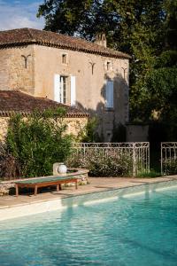 una casa e una piscina di fronte a un edificio di Château la Gineste - Castle and Vineyard a Duravel