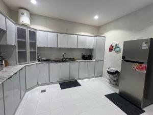 a kitchen with white cabinets and a stainless steel refrigerator at شقق روضة المطار in Abha